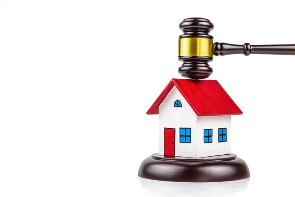A photo of gavel and small house on white background. This photo shoot in concept about Realestate law