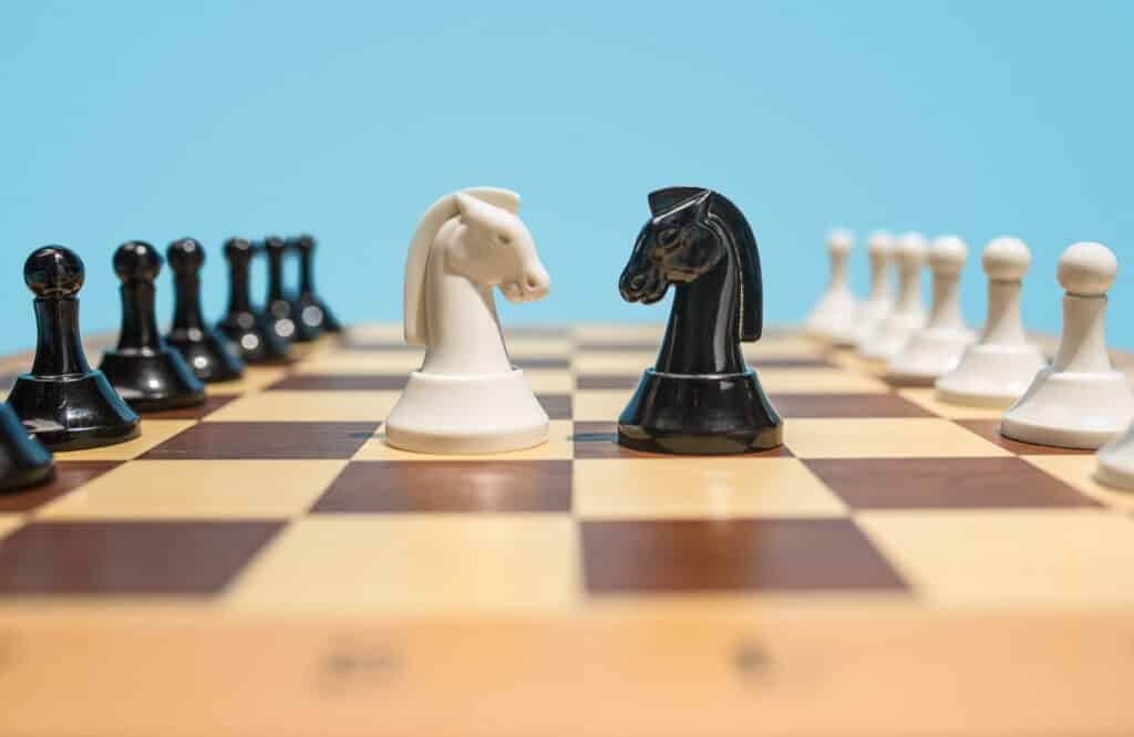 Struggle and confrontation. Chess board and game concept. Business ideas, competition, strategy and new ideas concept. Chess figures on blue background. Selective focus. Side view. Win, victory, winner concepts
